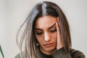 אישה מוטרדת בוחנת תסמינים בטלפון